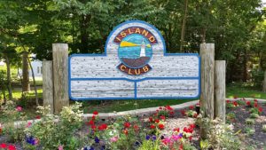 The entrance to the Island Club, greeted by its wooden sign.